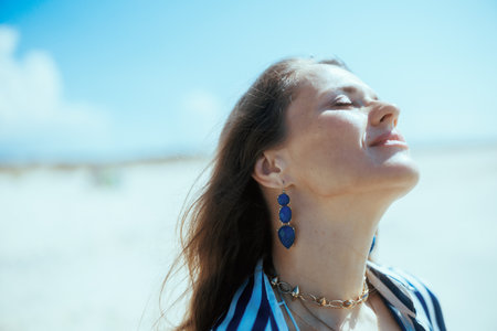 relaxed stylish female on the seashore enjoying peace of mind.の写真素材