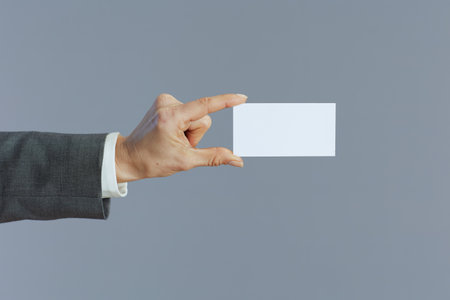 Closeup on woman employee with business card isolated on gray background.の写真素材