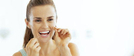 young woman using dental floss