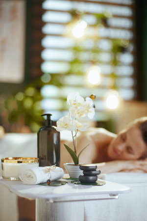 Healthcare time. Closeup on spa composition. in background relaxed woman in massage cabinet laying on massage table.の写真素材