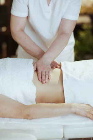 Healthcare time. Closeup on massage therapist in spa salon doing a therapeutic massage.の写真素材
