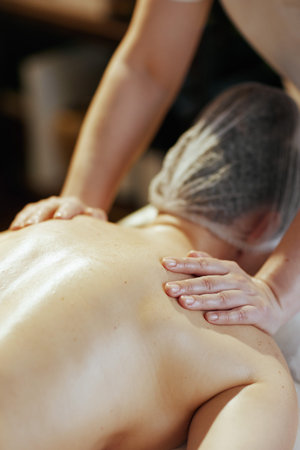 Healthcare time. Closeup on massage therapist in massage cabinet massaging clients back.