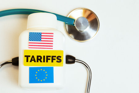 A white medicine bottle with USA and EU flags, labeled 'TARIFFS', lies beside a stethoscope, metaphorically examining economic policy side effects.の写真素材