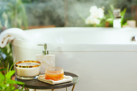 A close-up of thoughtfully arranged bath and self-care itemsâ€”candle, soap dispenser, body...