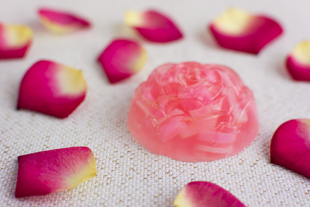 Organic homemade rose soap. Delicate rose petals on the background.の写真素材