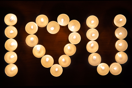 Burning candles arranged in the shape of heart. Inscription I LOVE YOUの写真素材
