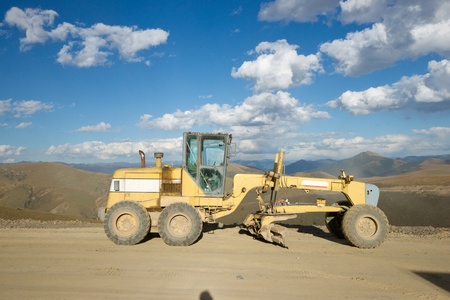 Road building machine with highland landscapeの写真素材