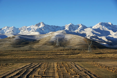 Telegraph pole with snow mountainの写真素材