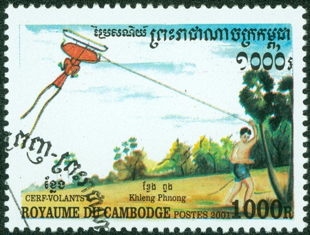 CAMBODIA - CIRCA 2001  stamp printed by Cambodia, shows a boy flying a kite, circa 2001 のeditorial素材