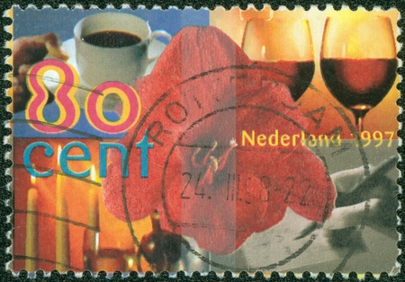 NETHERLANDS - CIRCA 1997  A greeting stamp printed in Netherlands shows Cup of coffee, glasses of wine, candles, writing letter, and amaryllis, circa 1997の写真素材