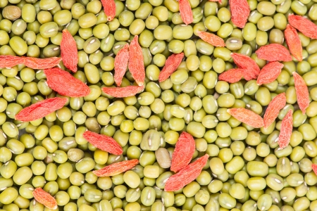 Green mung beans with red chinese wolfberry fruit backgroundの写真素材