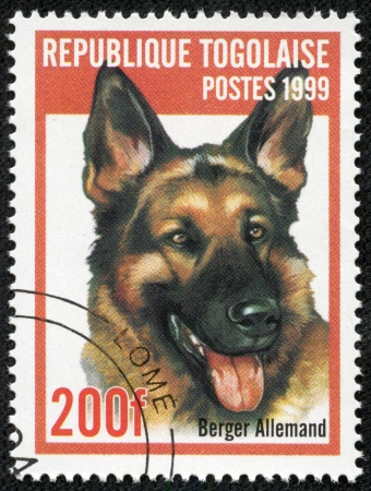 REP OF TOGO - CIRCA 1999  mail stamp printed in Togo shows a dog, circa 1999のeditorial素材