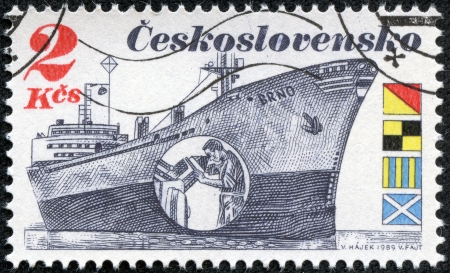 CZECHOSLOVAKIA - CIRCA 1989  A stamp printed in Czechoslovakia shows the Czech Freighter Brno with inset showing a man peering at radar display  Flags spell  OLGM  in English, circa 1989 のeditorial素材