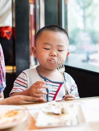 Asian boy was dining In the restaurantの写真素材