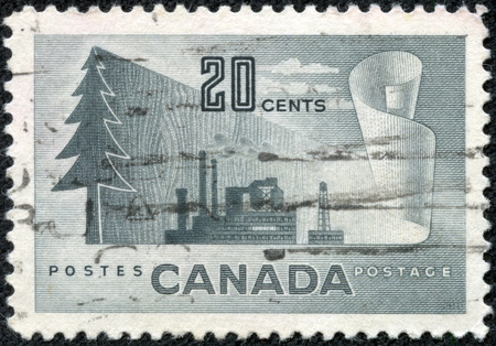 CANADA - CIRCA 1952: A stamp printed in Canada shows image of a tree and an industrial plant, series, circa 1952のeditorial素材