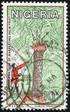 NIGERIA - CIRCA 1986  A stamp printed in Nigeria, shows modern method of harvesting palm fruit, circa 1986のeditorial素材