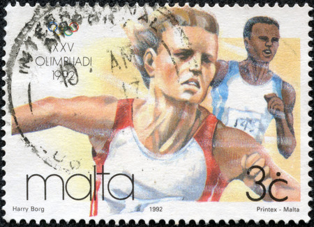 MALTA - CIRCA 1992  a Maltese stamp shows image of an athlete competing in the 1992 Barcelona Olympics, circa 1992のeditorial素材