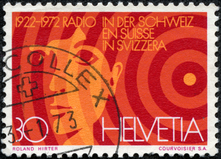 SWITZERLAND - CIRCA 1972  A stamp printed in Switzerland, is dedicated to the 50th anniversary of Radio Switzerland, shows the head boy and radio waves, circa 1972のeditorial素材