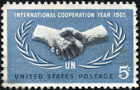 UNITED STATES - CIRCA 1965: A 5 cents stamp printed in the United States shows International Cooperation Year Emblem, circa 1965のeditorial素材
