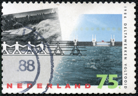 NETHERLANDS - CIRCA 1986: a stamp printed in the Netherlands shows Barrier Withstanding Flood, Delta Project Completion, circa 1986のeditorial素材