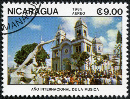 NICARAGUA - CIRCA 1985: a stamp printed in Nicaragua shows crowd of people near the entrance to the Church of Nicaragua. Series of stamps "Year of international music", circa 1985のeditorial素材