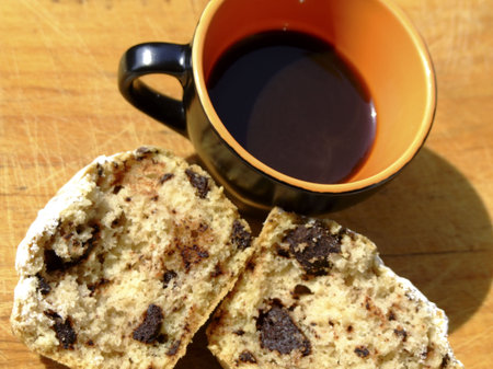 A cup of italian style black coffee and muffin with chocolate chips