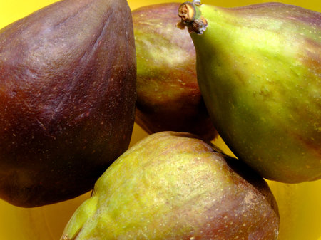 Four ripe figs in a yellow bowl