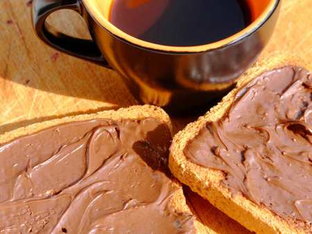Close-up of a cup of coffee and two rusks with chocolate creamの写真素材