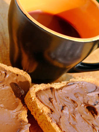 Close-up of a cup of coffee and two rusks with chocolate creamの写真素材