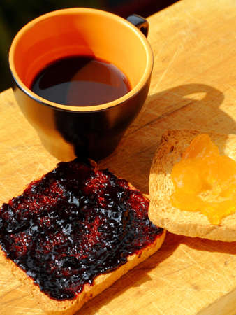 Close-up of a cup of coffee and two rusks with jamの写真素材