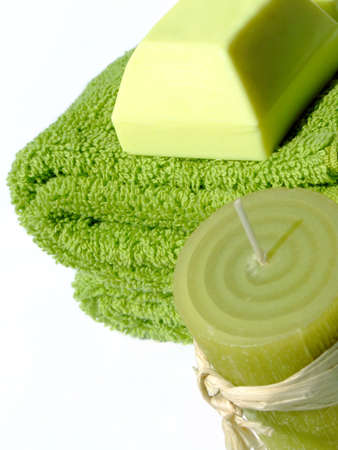 Two green towels a piece of green soap and a green candle on white backgroundの写真素材
