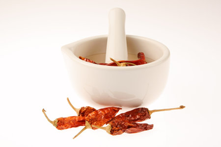 Close-up of a mortar and pestle with some dried red hot chili peppersの写真素材