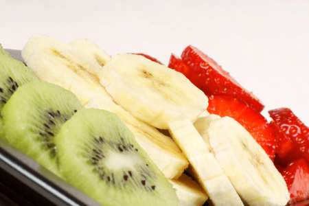 Close up of slices of kiwi, banana and strawberry. It could represent an organic italian flag. の写真素材