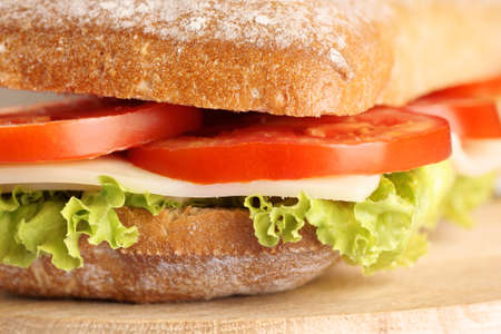 Close-up of an italian panino (sandwich) with freshly baked ciabatta bread, lettuce, cheese and tomato. Extreme shallow DOF, selective focus.の写真素材