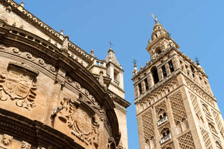 Detail of the gothic and baroque Cathedral of Seville and the famous bell tower called La Giralda that was previously a minaret of the Berber Almohad period in Spain の写真素材