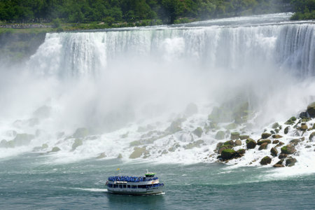 Niagara Falls, USA - August 2, 2008: American Falls at Niagara on the US - Canadian border. On the water a touristic boat called Maid of the Mist that takes tourists around the falls for amazing trips. A lot of people around.のeditorial素材