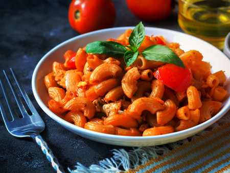 Macaroni pasta with tomato sauce in white plate on grey color tableの写真素材