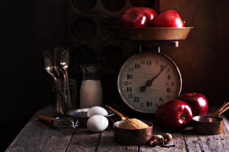 Baking ingredients on rustic table apples, eggs and sugarの写真素材