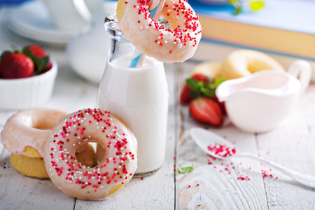 Baked donuts with pink glaze and sprinklesの写真素材