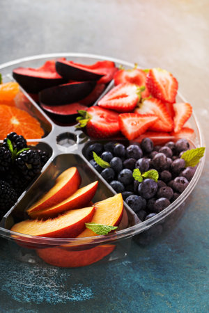 Assorted fruit and berries on a plate with strawberry, peaches, blackberry and orangeの写真素材