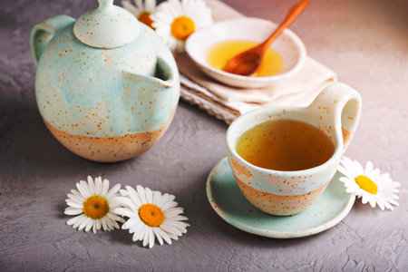 Hot camomille tea with honey in handmade ceramic cupの写真素材