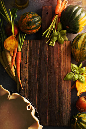 Baking with autumn vegetables concept with pie pastry, carrots and yellow beetsの写真素材