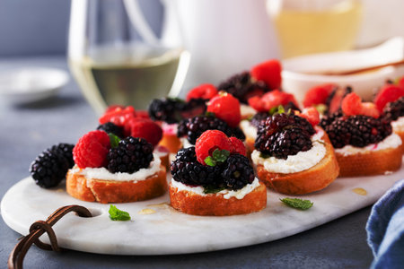 Berry and goat cheese bruschetta with fresh mint and honeyの写真素材