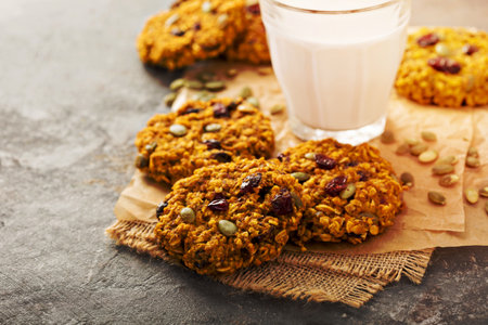 Breakfast oatmeal cookies with pumpkin puree, cranberry and seeds with milkの写真素材