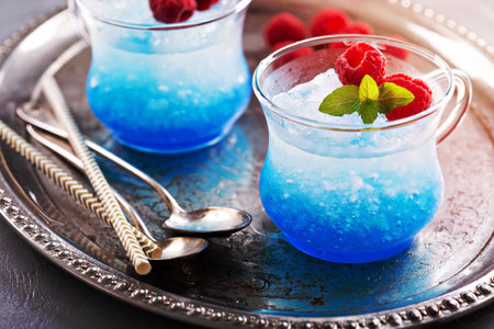 Blue raspberry cocktail with mint in small glass cupsの写真素材