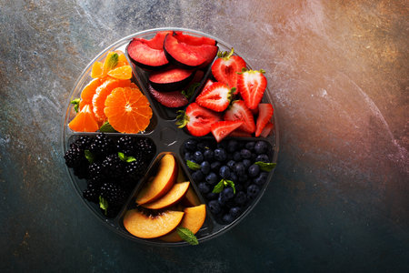 Assorted fruit and berries on a plate with strawberry, peaches, blackberry and orangeの写真素材