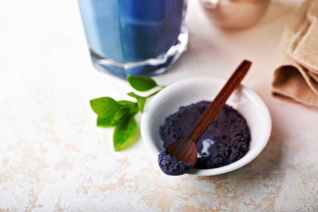 Blue matcha tea powder and latte in tall glass, tea from the dried flowers of the butterfly pea plantの写真素材