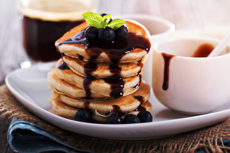 Eggless pancakes for breakfast with blueberries and chocolate sauceの写真素材