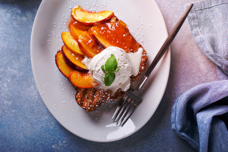 French toast with fresh peaches and vanilla ice cream for breakfastの写真素材