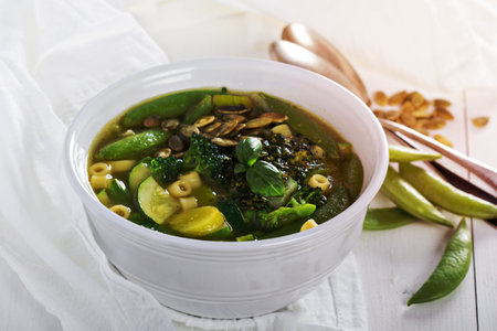 Green minestrone with a lot of vegetables and pastaの写真素材